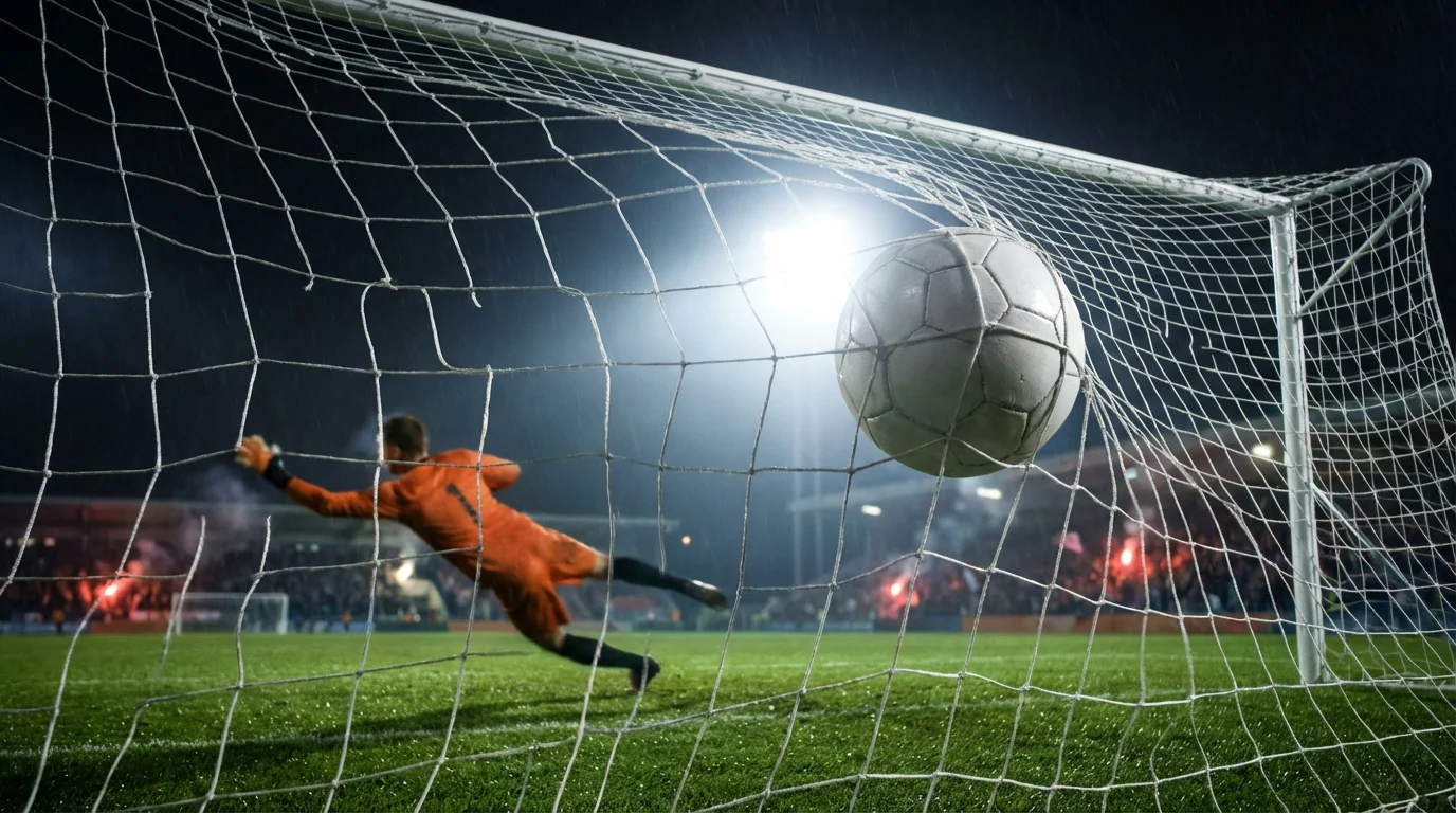 Voetbal die het net raakt bij een doelpunt in een verlicht stadion tijdens een avondwedstrijd